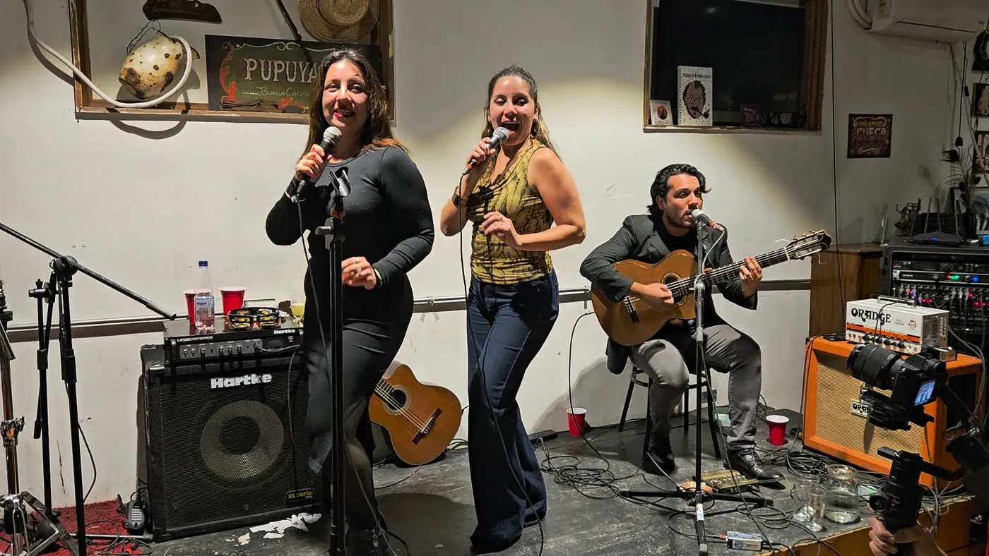 Dos cantantes y un guitarrista en vivo en el festival aniversario de Paneo Army