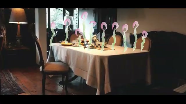 Fotograma del videoclip de Molino: figuras rotoscopiadas bailando sobre una mesa servida