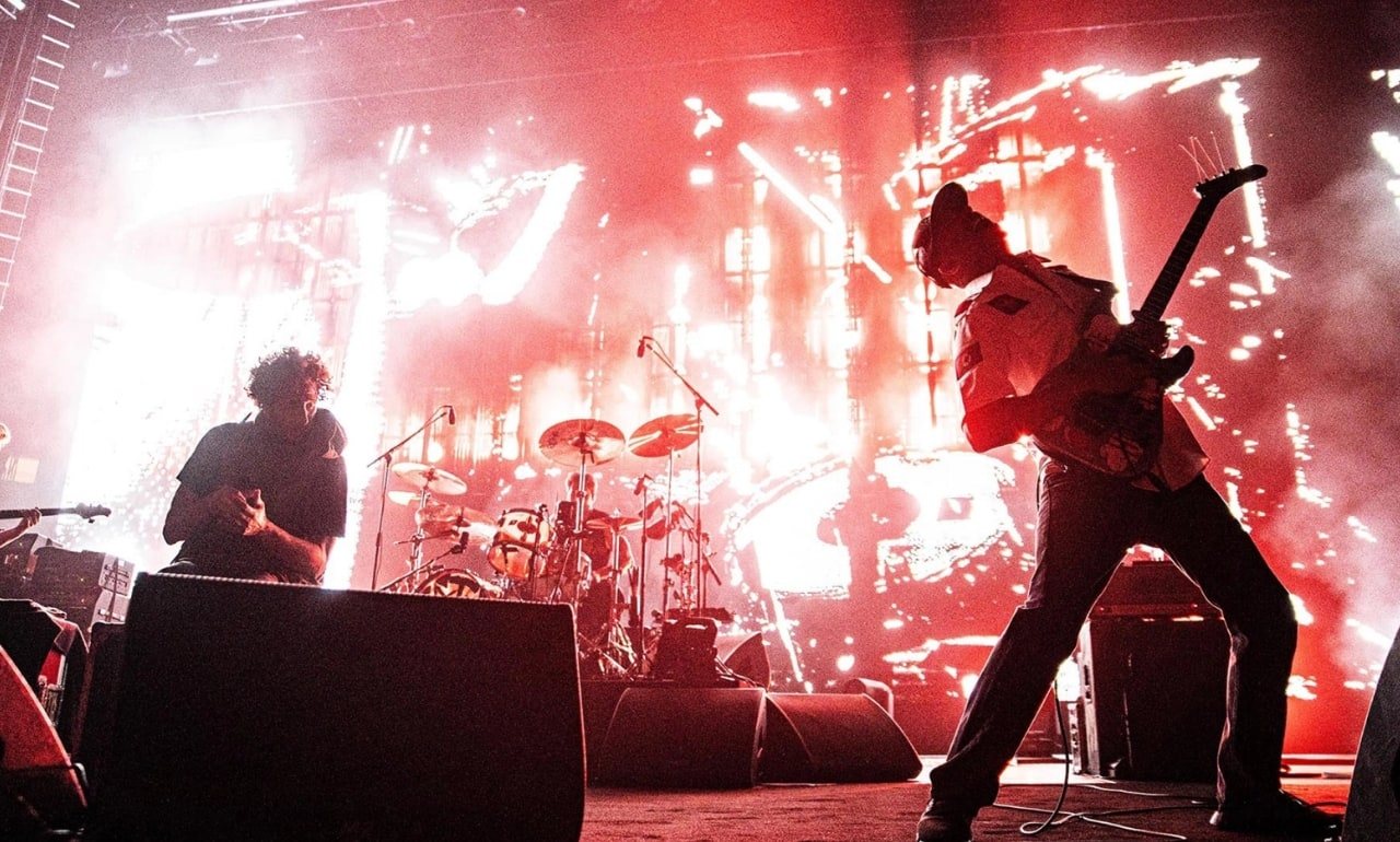 Rage Against the Machine en vivo, con el escenario iluminado en rojo