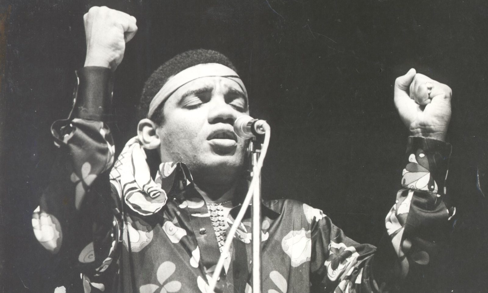 Wilson Simonal canta con los ojos cerrados y los puños en alto frente al micrófono, en 1969.